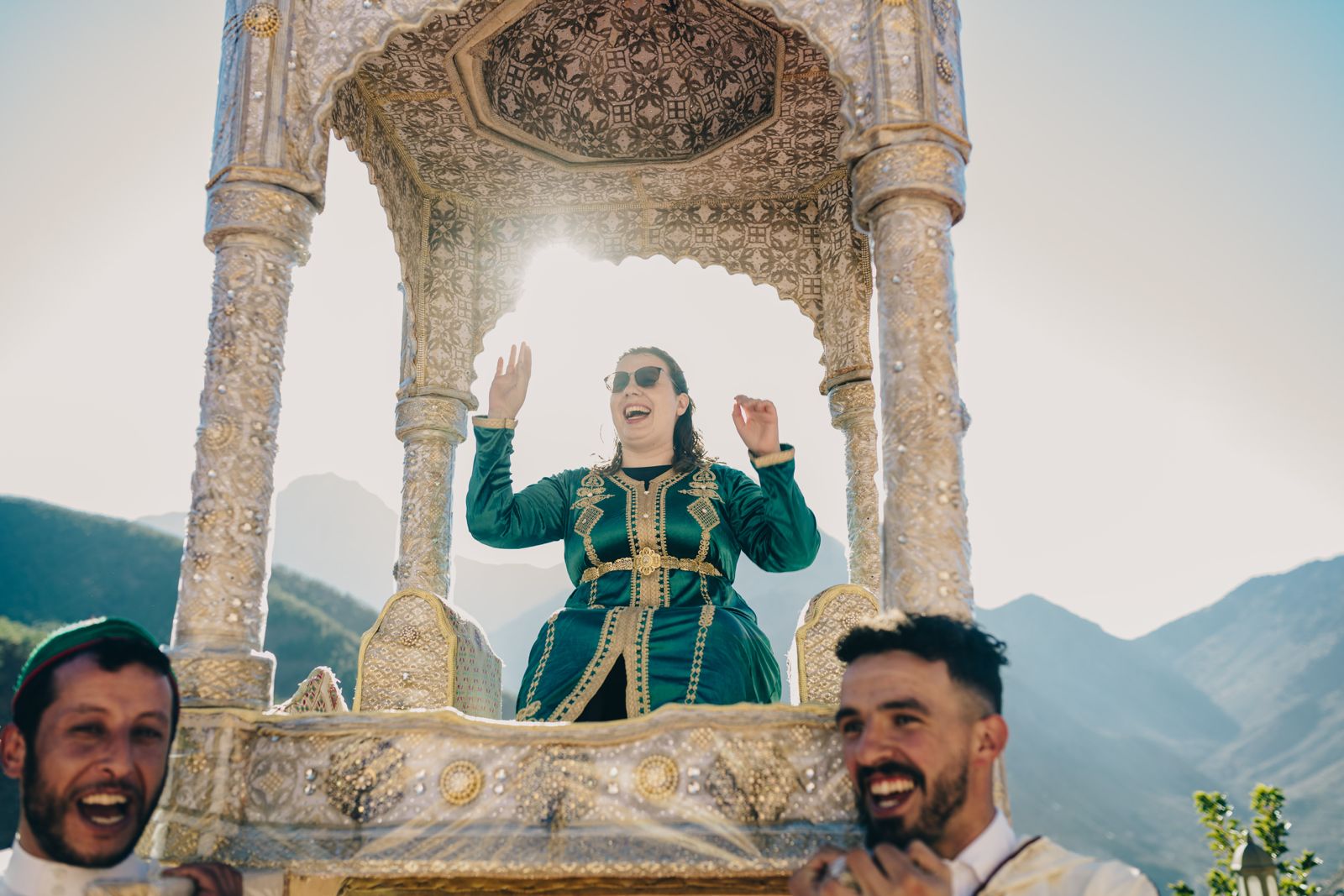 A guest smiling in a traditional green kaftan under the Amariya canopy