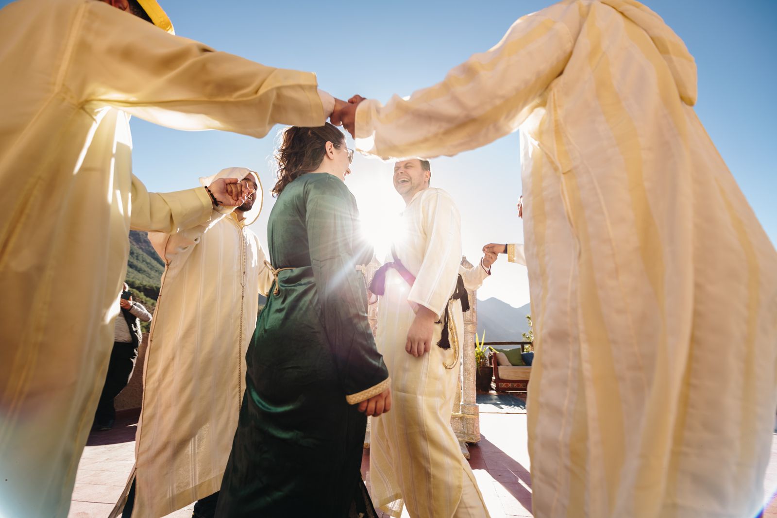 Guests dancing hand in hand in a circle with local musicians in the Atlas Mountains