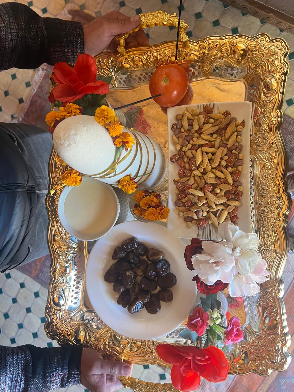 A golden tray with mint tea, dates, nuts and flowers for the traditional welcome
