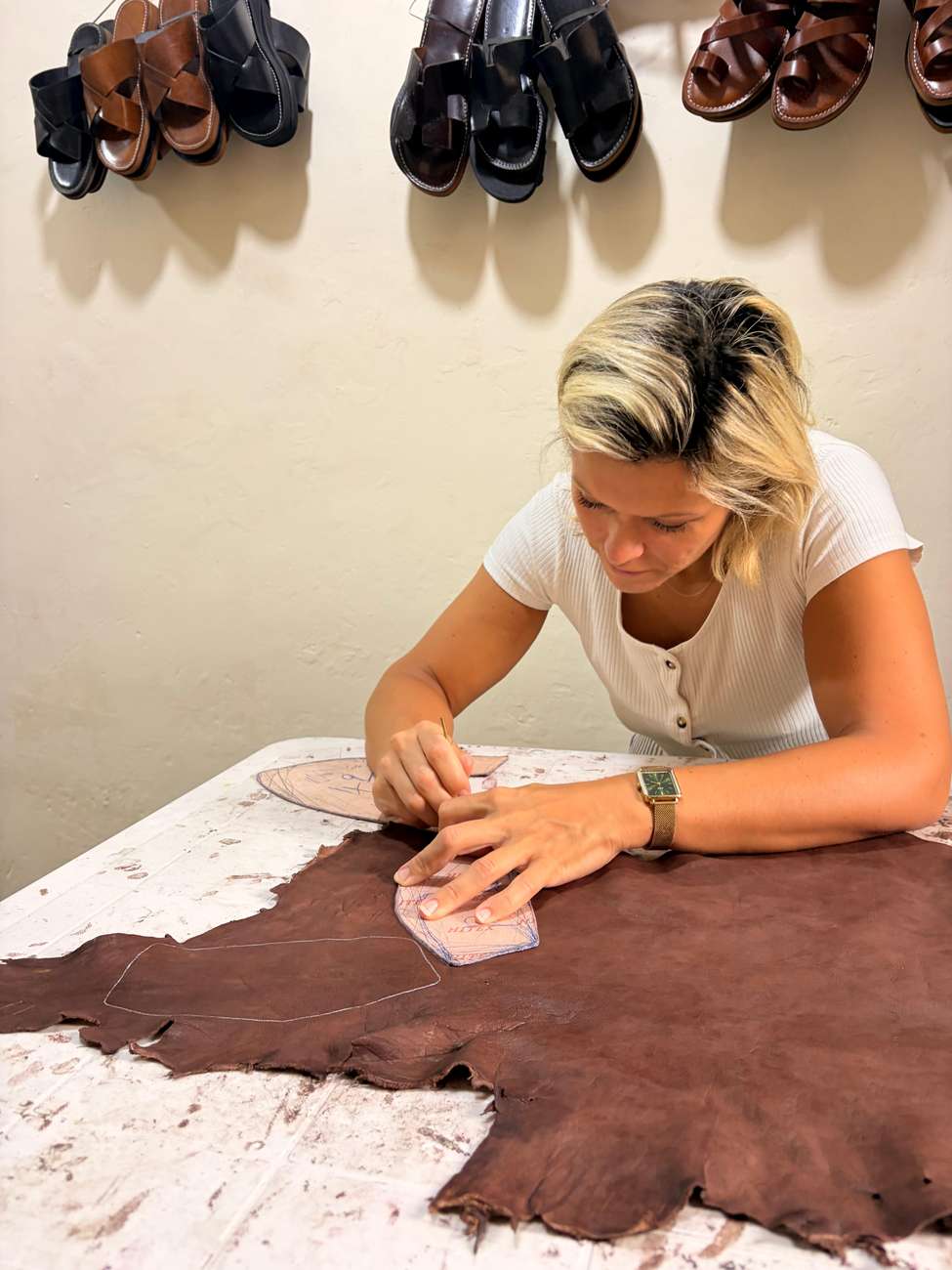 A craftsman cutting a pattern into a piece of leather