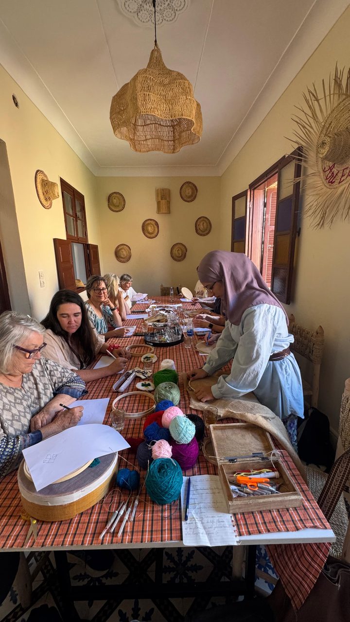 Guests embroidering around a long table during the workshop