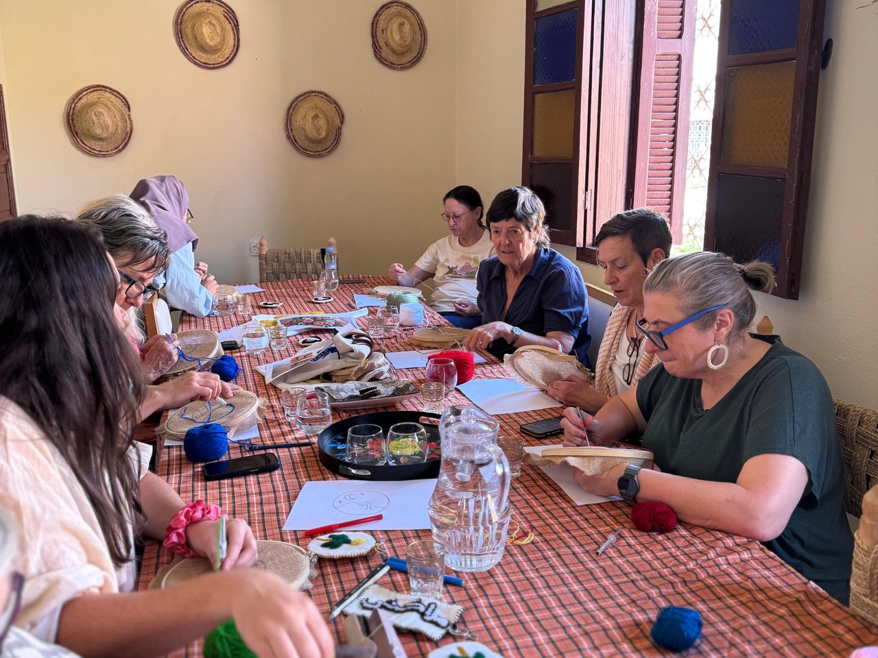 Guests stitching their embroidery around the table