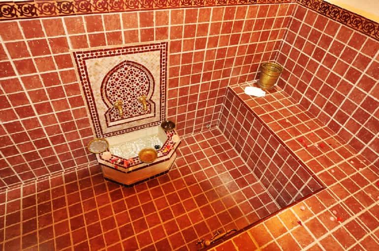 A traditional Moroccan hammam with red zellige tiles