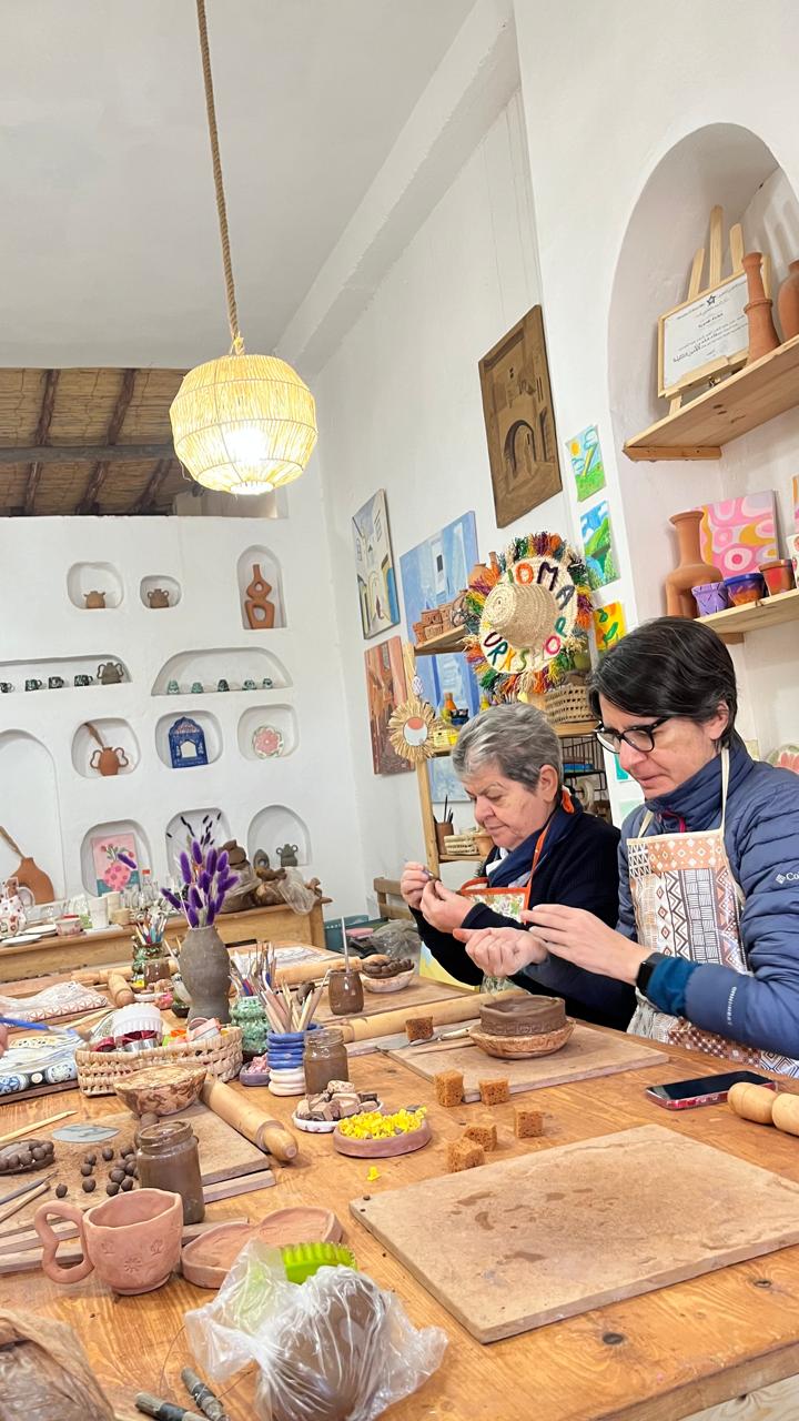 Guests painting their finished pottery pieces